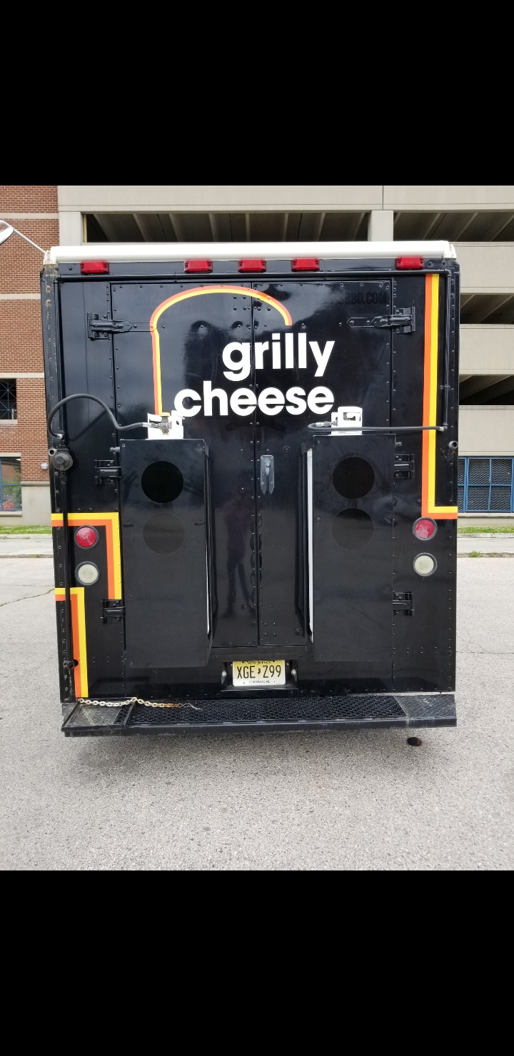 Rear view of the Grilly Cheese food truck showing full branding, logo and New Jersey license plate